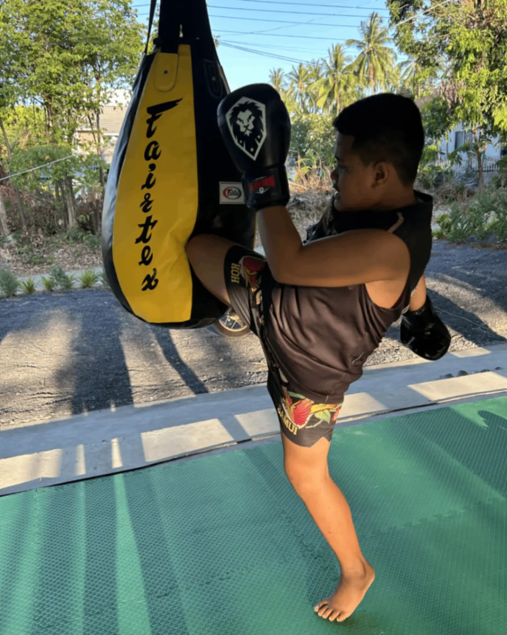 Young boy kicking the heavy bag