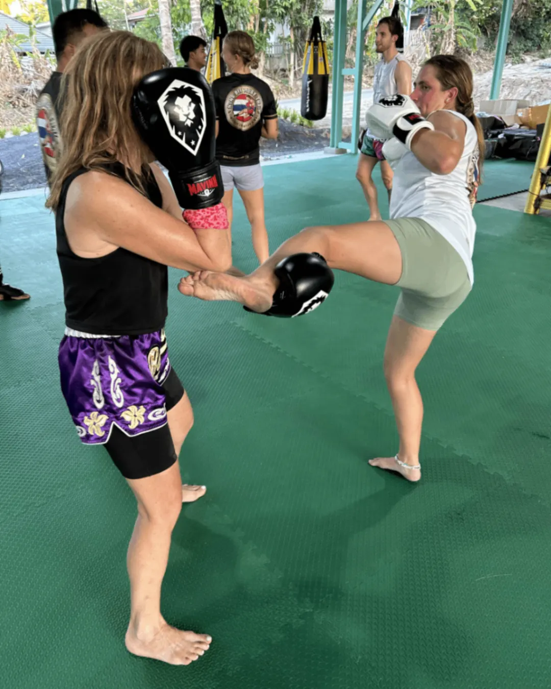 Women sparring — kick exchange