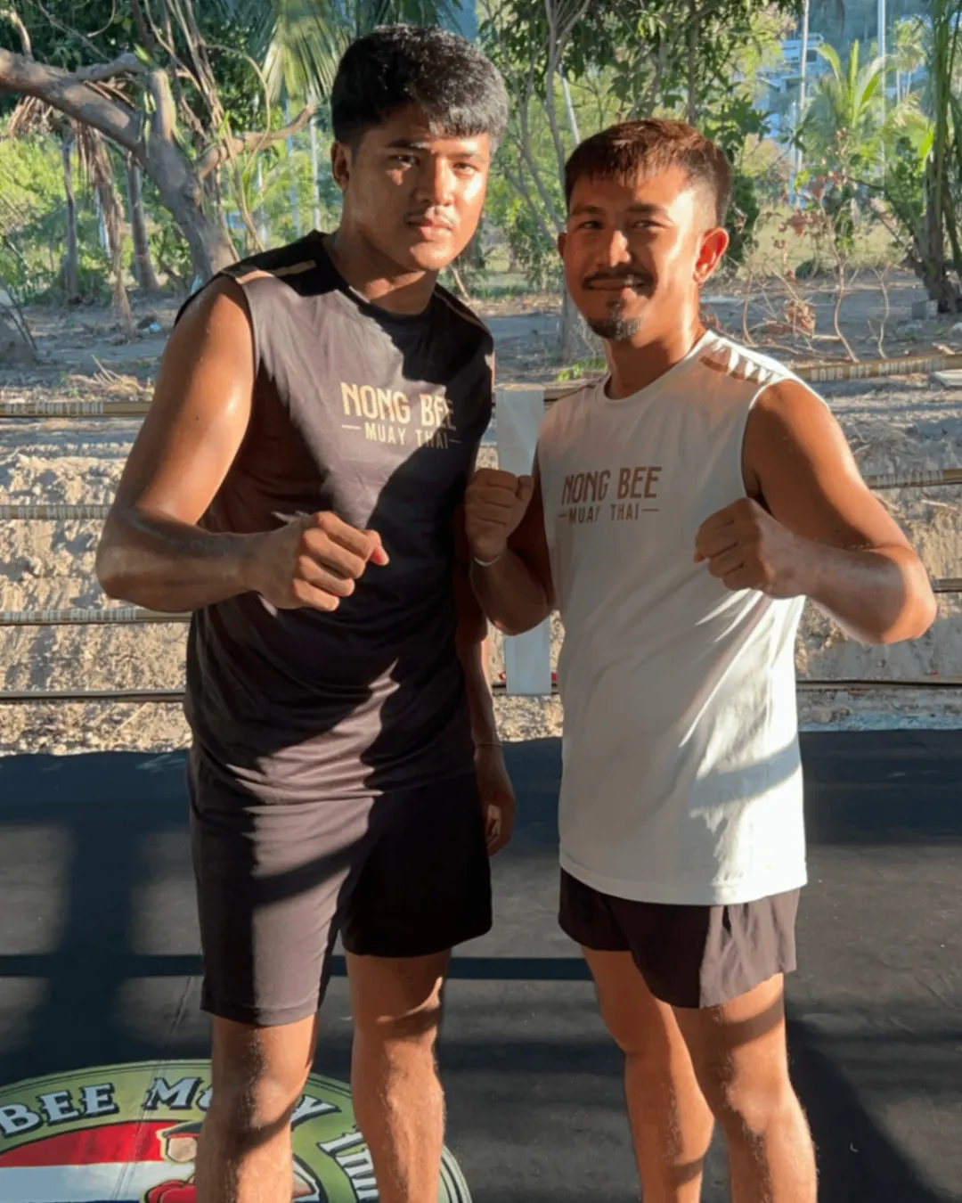Two trainers posing in Nong Bee shirts